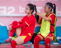 Huỳnh Như tết tóc cho Trần Thị Duyên trên hàng ghế dự bị trước trận bán kết hôm 14/12. Ảnh: Duy Hiệu.